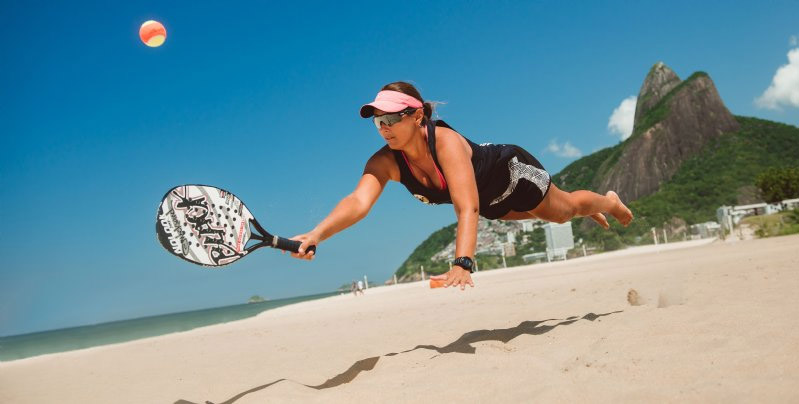 jogadora de beach tennis se jogando na areia